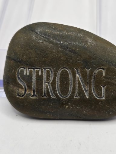 laser engraved river rock with word strong